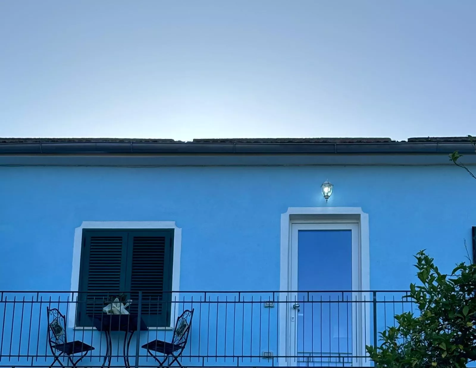 La casa azzurra con il balcone e le persiane verdi