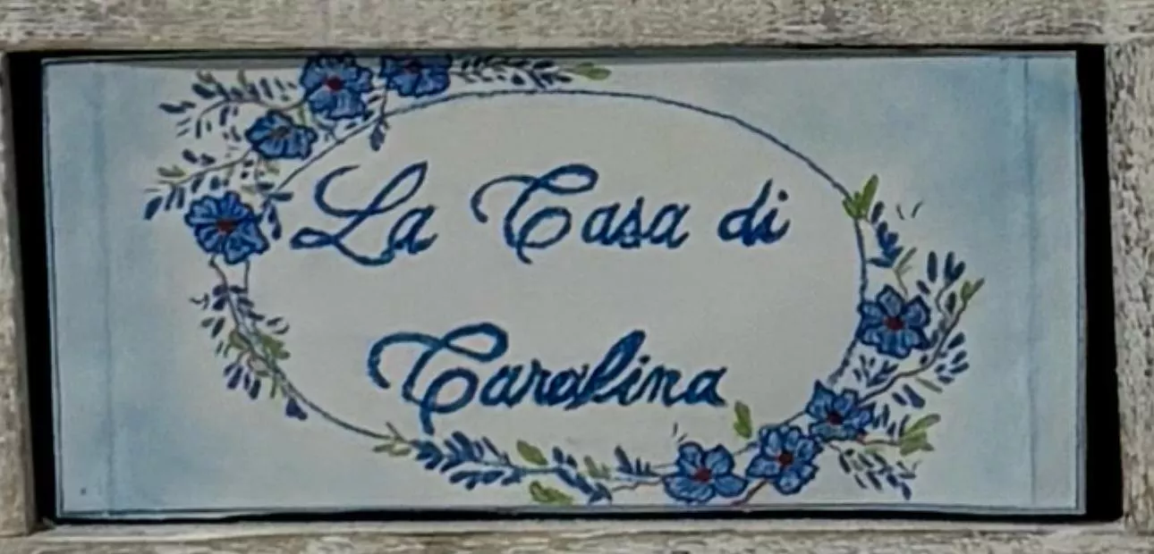 L'insegna in ceramica dipinta della Casa di Carolina